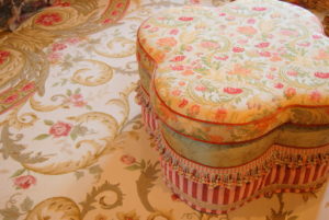 Decorative floral ottoman on matching area rug