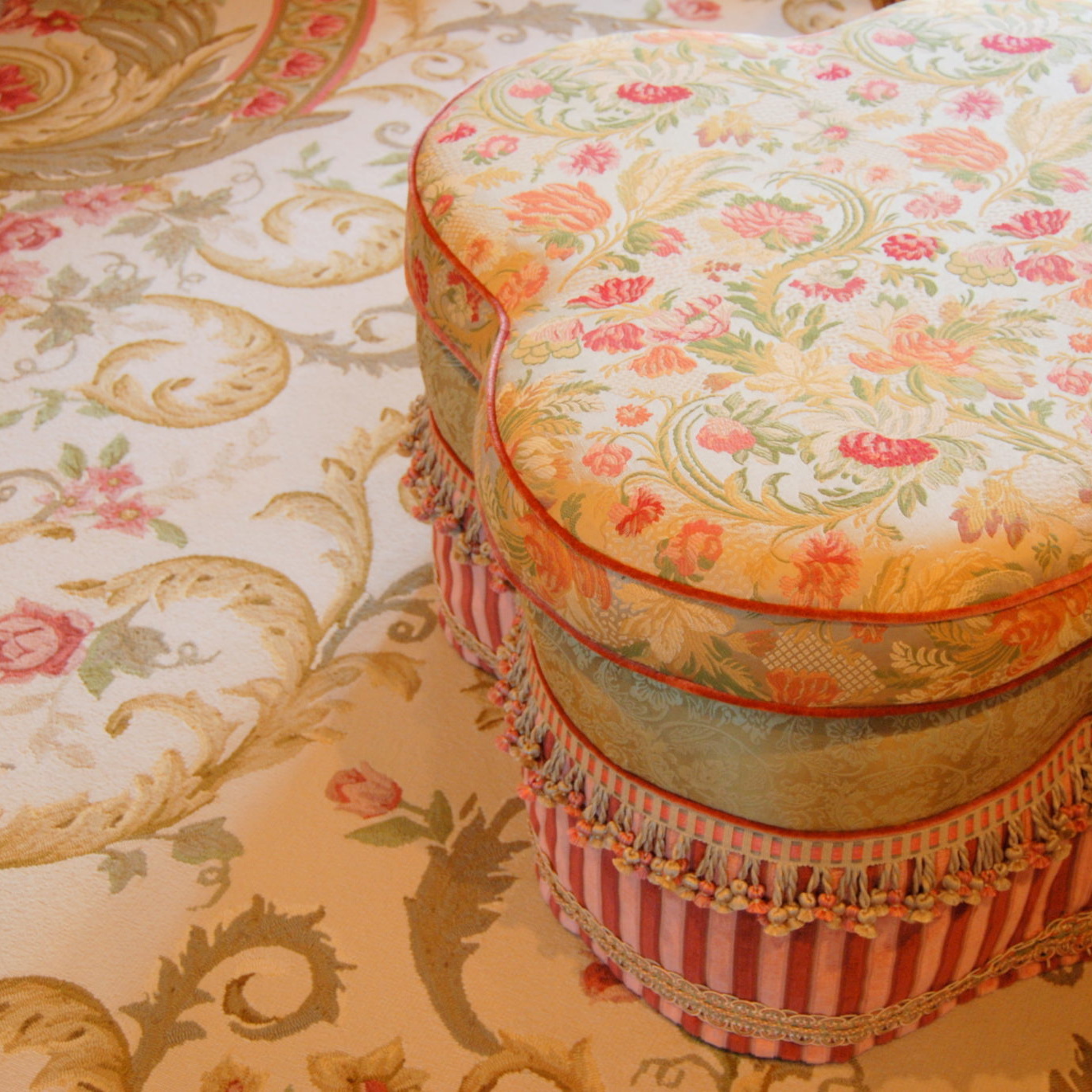Decorative floral ottoman on matching area rug