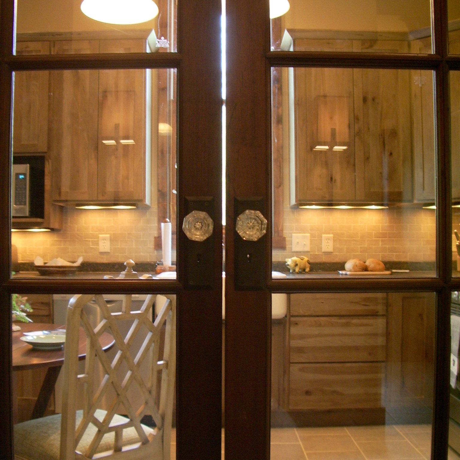 Two glass doors leasing into a rustic kitchen