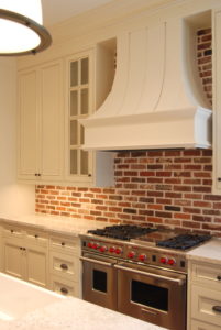 Newly remodeled kitchen with stainless steel stove and brick backsplash
