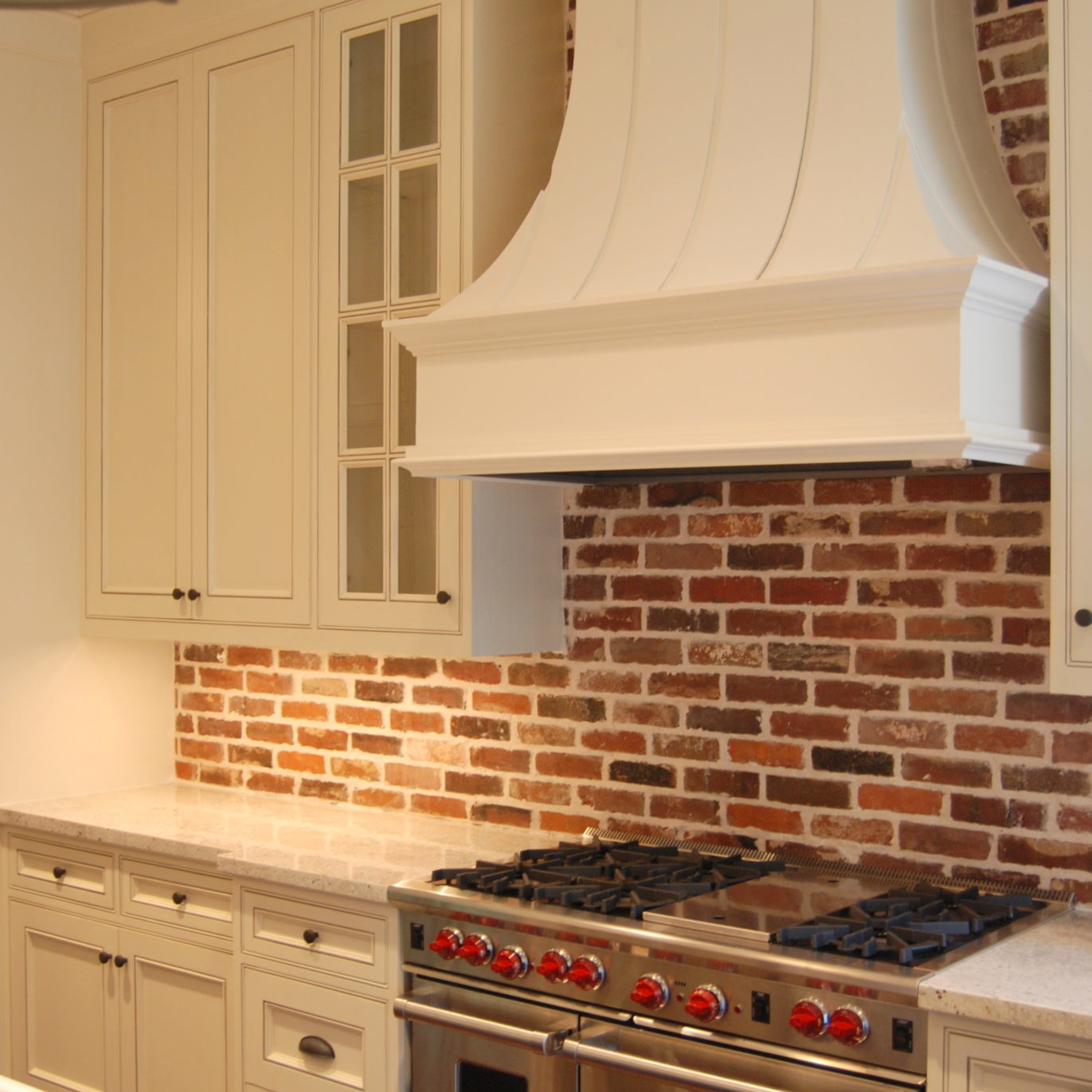 Newly remodeled kitchen with stainless steel stove and brick backsplash