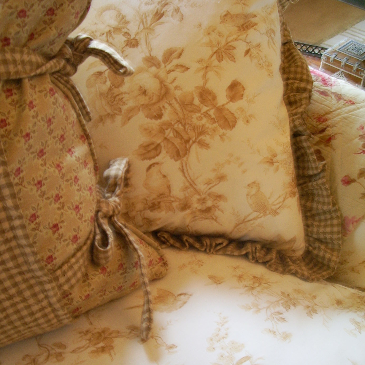 Closeup of decorative pillows with birds and flowers