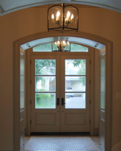 Entryway with large doors and modern chandeliers