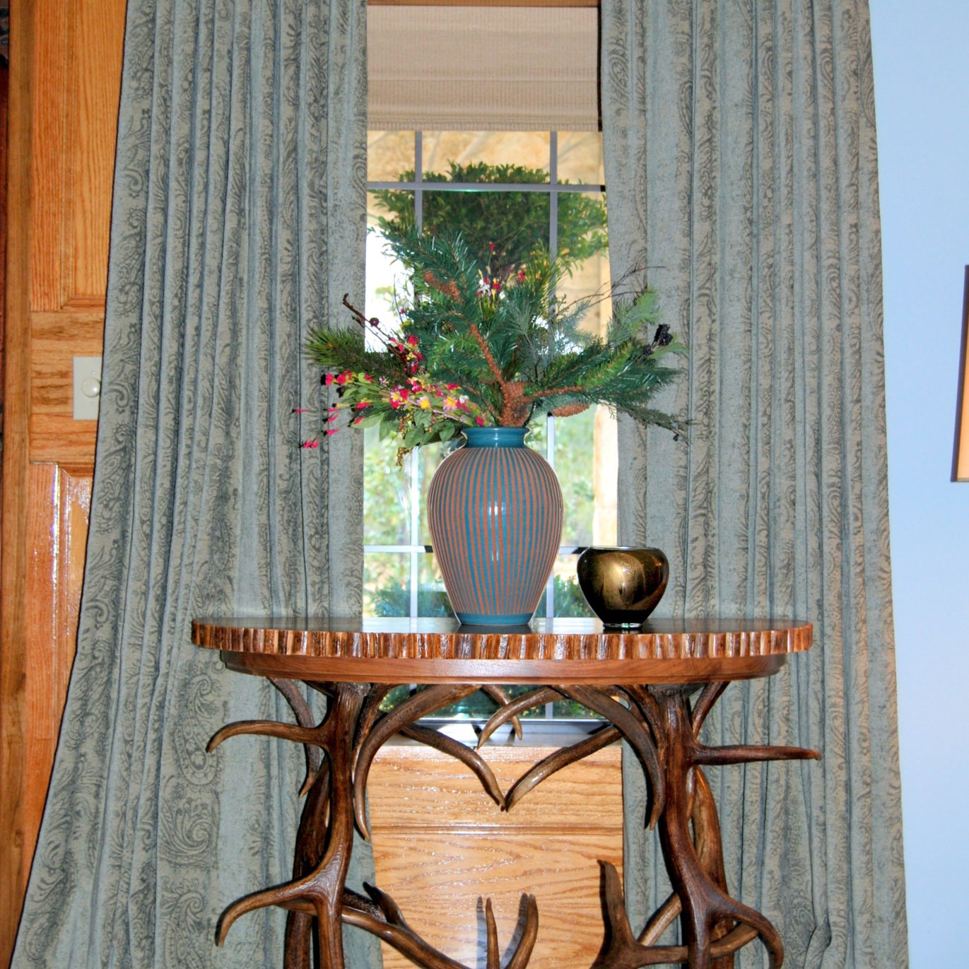 Rustic antler table with a plant by a window