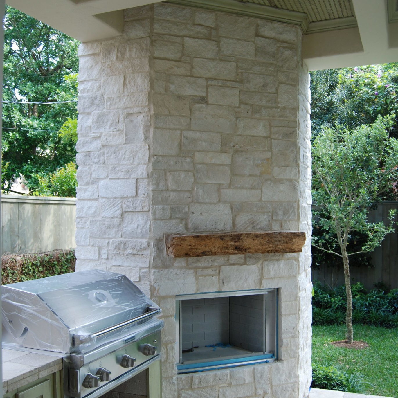 Outdoor patio design with grill and wood stove
